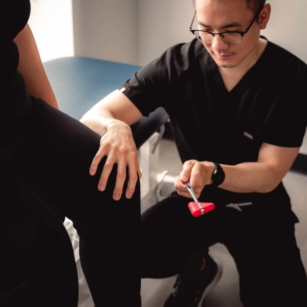 dr tim lau checking the patient's knee pain